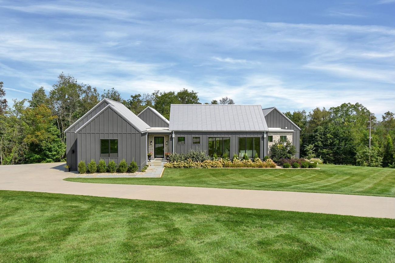 Red Cherry — modern farmhouse of linked gray pavilions on open acreage